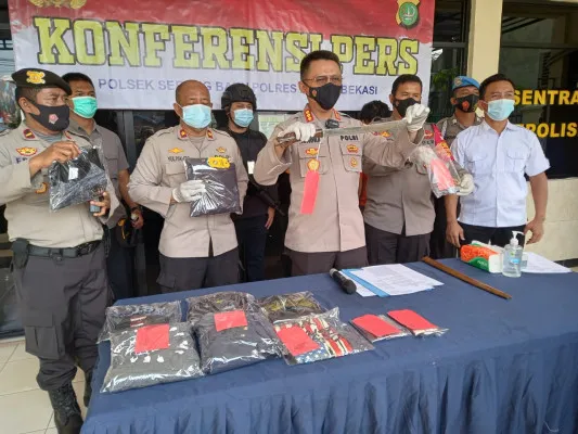 Aparat kepolisian menunjukkan barang bukti yang dimiliki kedua tersangka kala melakukan aksinya saat konferensi pers yang digelar di Mapolsek Serang Baru, Senin (24/5/2021) (ist)