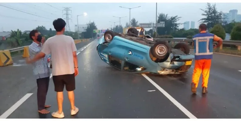 Sebuah mobil taksi terguling akibat kecelakaan beruntun yang terjadi di Jalan Tol Meruya Selatan, Kembangan, Jakarta Barat. (ist).