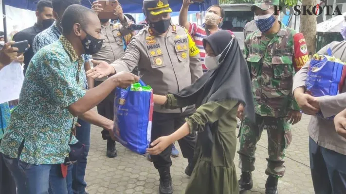 Kapolres Tangerang Selatan AKBP Iman Imanuddin bersama mahasiswa Papua membagikan sembako kepada masyarakat. (toga) 