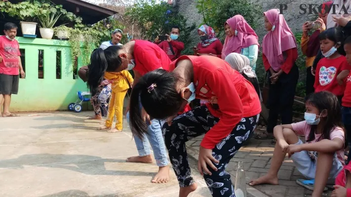 Empat anak kecil tengah mengikuti perlombaan di Karang Tengah. (Iqbal)