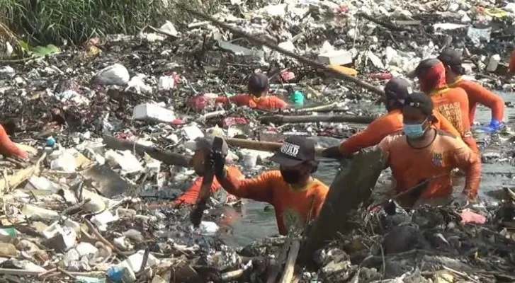 Para petugas dari dari dinas lingkungan hidup sedang membersihkan sampah yang menumpuk di aliran kali Busa Desa Satria Mekar, Tambun Utara, Bekasi, Jum'at (10/09/2021). (ist)