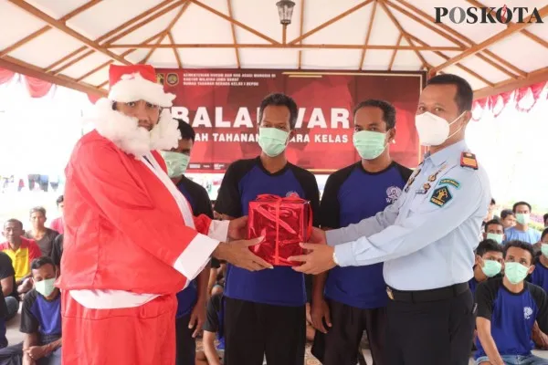 Kepala Rutan Kelas 1 Depok, Andi Gunawan  bersama WBP berpakaian costum Santa Clause memberikan bingkisan sebagai kado remisi  untuk WBP. (foto: poskota/ angga pahlevi)