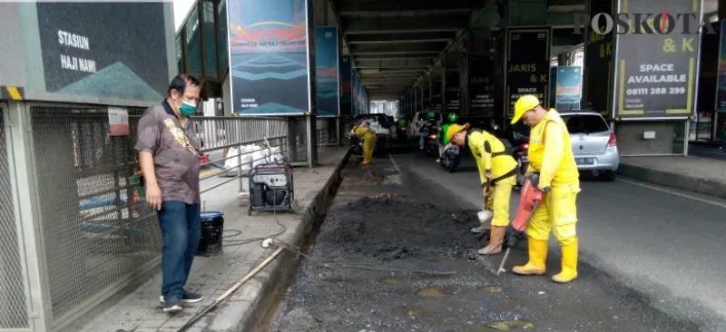 Petugas memperbaiki jalanan rusak di dekat Stasiun MRT Haji Nawi, Jl. Raya Fatmawati, Jaksel. (foto: poskota/ adji)