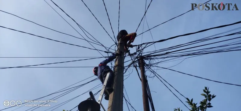 Petugas Damkar mengevakuasi pria diduga stress memanjat tiang listrik hingga berhari-hari. (foto:poskota/panca)