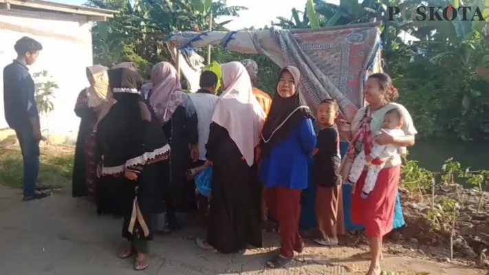 Warga setempat saat antri melihat bunga bangkai di bantaran kali Cikarang. (ihsan fahmi)