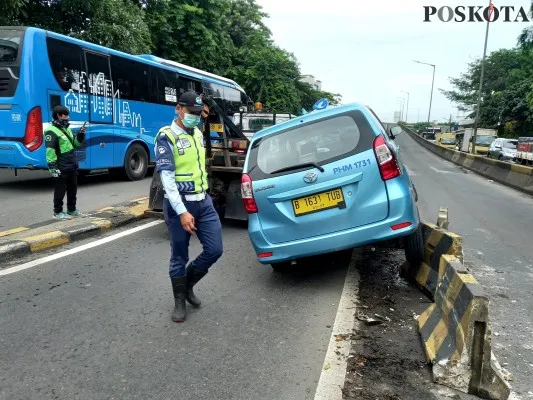 Sebuah taksi menghantam separator di Jalan Daan Mogot, Jakarta Barat. (foto: pandi)