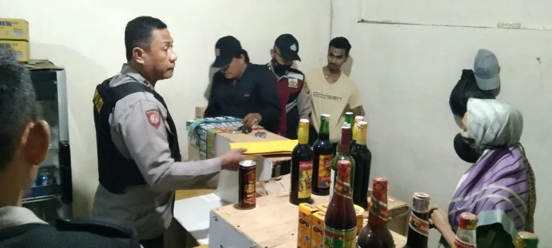 Polsek Tajur Halang menyita puluhan botol miras dari warung jamu milik pasutri. (foto: angga)