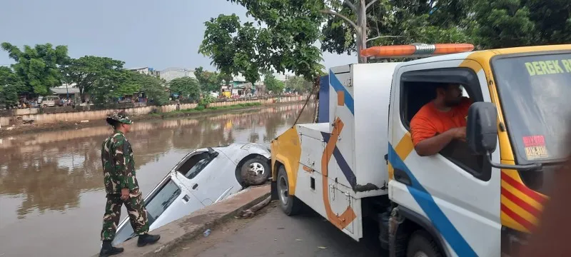 Kendaraan roda empat terperosok ke Kali Cengkareng Drain di kawasan Jembatan Gantung, Kembangan, Jakbar. (ist)