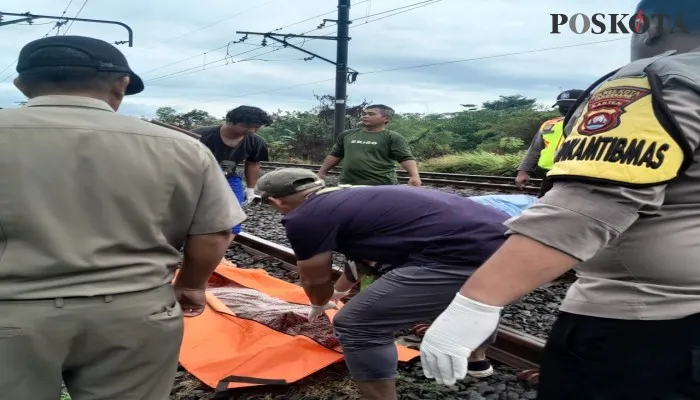 Petugas kepolisian saat melakukan evakuasi korban terserempet kereta. (Foto/Veronica)