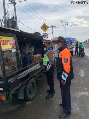 Foto : Petugas gabungan Polantas dan Dishub Beji, Kota Depok, menertibkan PKL dan taksi online yang mengetem di bahu jalan membuat macet lalu lintas ditertibkan. (Poskota/Angga Pahlevi)