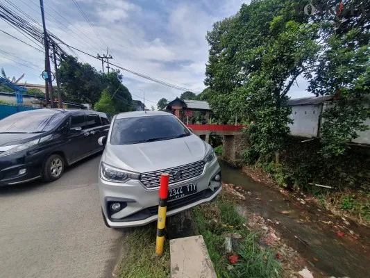 Suzuki Ertiga nyaris nyempung ke Kali Licin Depok, diduga sopir hilang konsentrasi saat hindari motor. (foto: angga)