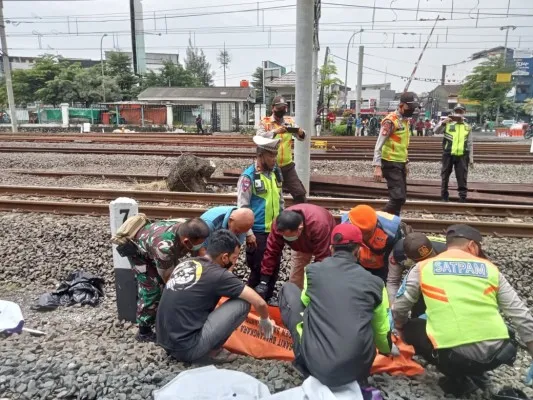 Petugas gabungan mengecakuasi jenazah wanita yang diduga sengaja menabrakan diri ke kereta di Bekasi. (Ist)