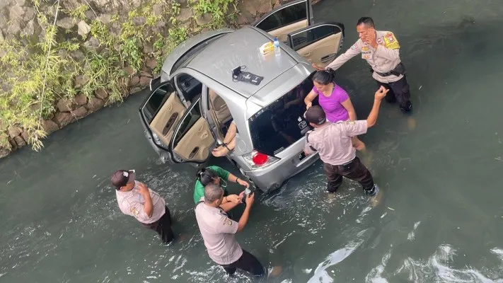 Petugas kepolisian saat melakukan evakuasi korban dan mobil nyemplung parit di pondok gede Bekasi. (Humas SAR Bekasi).