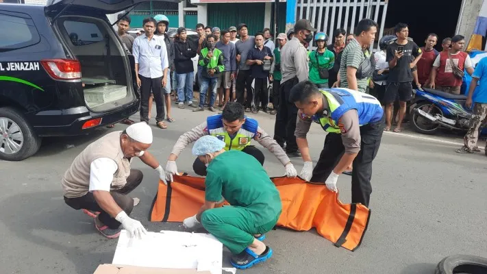 Foto: Personil Unit Gakkum Satlantas Polresta Serang Kota, Banten, saat mengevakuasi jasad balita yang tertabrak truk. (ist.)