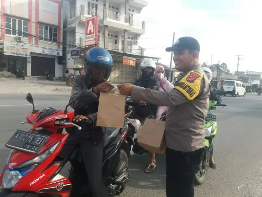 Personil Polsek Cikande saat memberikan takjil kepada pengguna jalan. (ist)