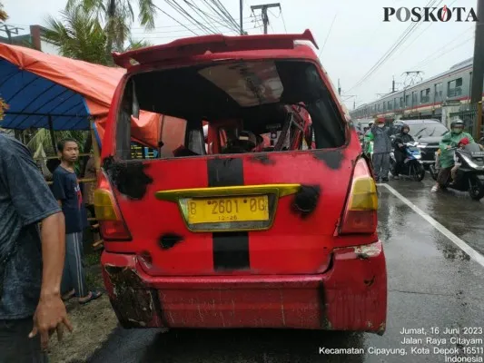 Mobil angkot jurusan Terminal Depok - Depok 2ringsek dihantam KRL di perlintasan kereta Depok. (angga)