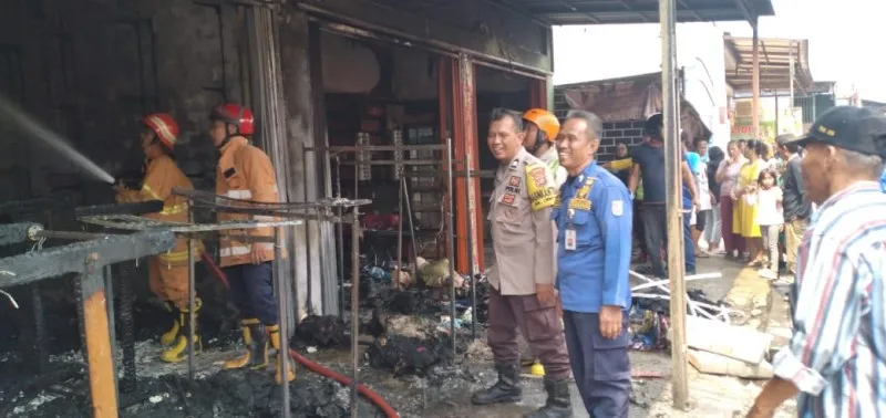 Petugas Damkar Depok memadamkan api yang membakar toko pakaian di Cipayung. (Ist)