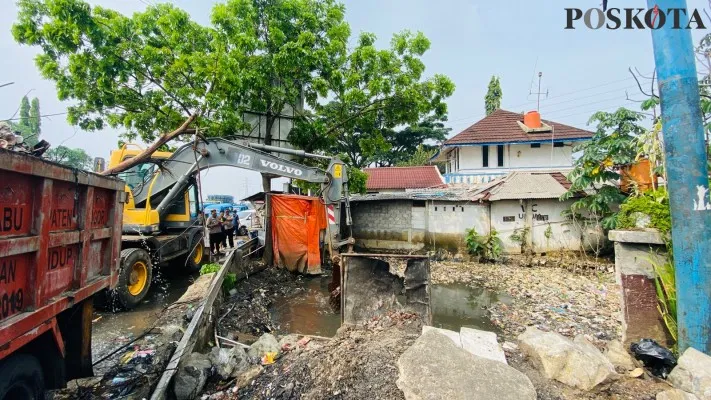 Tumpukan sampah di saluran irigasi Pasar Ciawi, Bogor diangkuti dengan alat berat. (Panca)