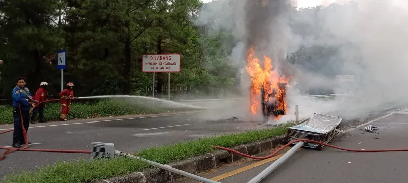 Petugas damkar memadamkan Toyota Alphard yang terbakar di Tol Bintaro. (Ist)