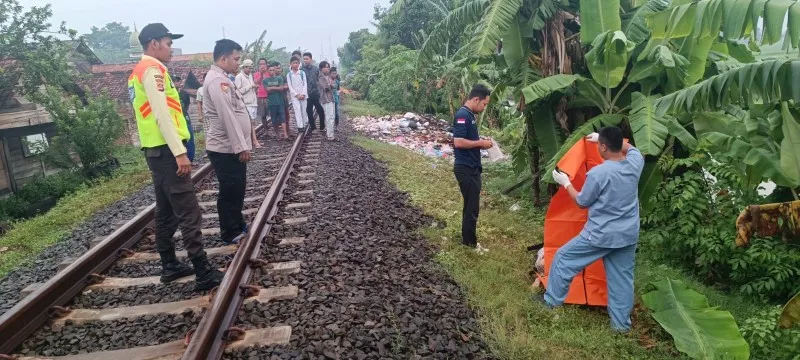 Personil Satreskrim Polresta Serang saat akan mengevakuasi jasad korban wanita di pinggir lintasan. (ist)