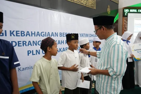 General Manager PLN UID Jakarta Raya, Lasiran saat menyerahkan santuan kepada adik-adik perwakilan dari Yayasan Masjid Al Firdaus.(Dok. PLN)