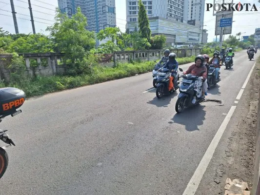 Pengendara sepeda motor hindari lubang di jalur Kalimalang, Tambun, Kabupaten Bekasi. (Poskota/Ihsan Fahmi)