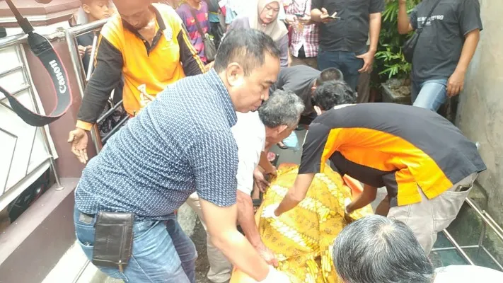 Petugas Polsek Matraman mengevakuasi jasad bayi laki-laki yang ditemukan setelah dilaporkan hilang  hanyut terbawa arus di selokan. (Dok Humas Polsek Matraman)