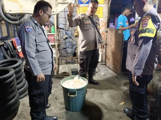 Petugas Polsek Ciruas mengamankan minuman tuak dari gubug tambal ban. (Dok. Polsek Ciruas)