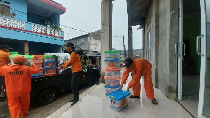 Petugas BPBD Tangsel saat mendistribusikan paket bantuan korban banjir. (Foto/BPBD Tangsel)