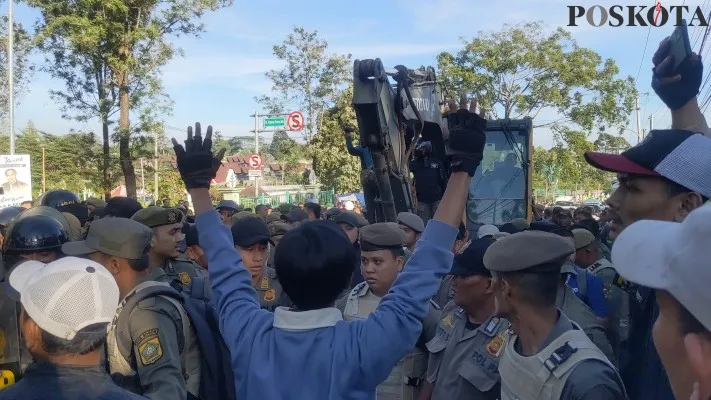 Para PKL di kawasan Puncak Bogor mengadang alat berat yang akan menertibkan lapak dagangan mereka. (Poskota/Panca Aji)