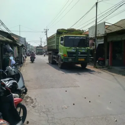 Truk pengangkut tanah beroperasi di Raya Pakuhaji-Sepatan, Kabupaten Tangerang, pada siang hari. (Poskota/Veronica)