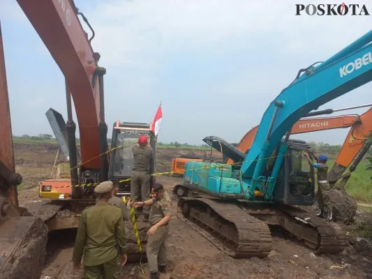 Petugas Satpol PP Kabupaten Tangerang saat melakukan penyegelan terhadap alat berat di lokasi galian tanah. (Poskota/Veronica)