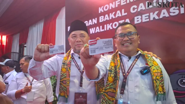 Heri Koswara dan Sholihin memperlihatkan kartu 'Beresin Bekasi' setelah mendaftar Pilkada di KPU Kota Bekasi, Rabu, 28 Agustus 2024. (Poskota/Ihsan Fahmi)