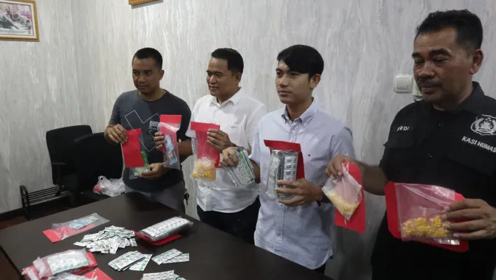 Kasatresnarkoba AKP Bondan Rahardiansyah didampingi KBO Ipda Edi Suryadi dan Kasi Humas AKP Dedi Jumhaedi menunjukkan barang bukti ribuan pil koplo dari tujuh tersangka. (Poskota/Rahmat)