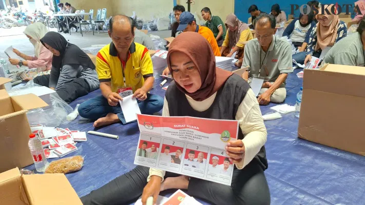 Cholifah (46) sedang melipat surat suara Pilgub Jabar di gudang logsitik KPU Kota Bekasi, di Alexindo, Bekasi Utara. (Poskota/Ihsan)