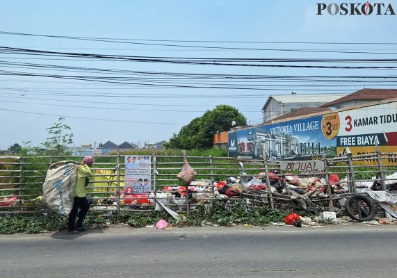 Pemulung melintas di lokasi tumpukan sampah di Jalan Tarumajaya Raya, Kecamatan Tarumajaya, Kabupaten Bekasi, Sabtu, 9 November 2024. (Poskota/Ihsan)