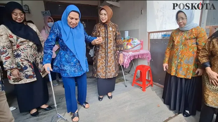 Fatma Saifullah Yusuf saat menuntun Siti Saubati di rumah kontrakan di Medan Satria, Kota Bekasi, Sabtu, 9 November 2024.  (Poskota/Ihsan)