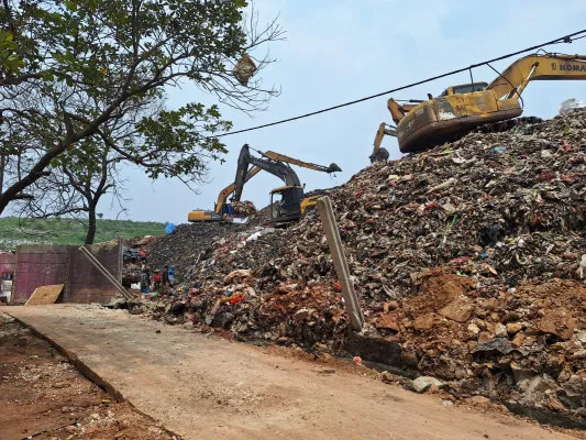 Dua alat berat saat mengeruk sampah di pinggir dinding roboh TPA Burangkeng, Setu, Kabupaten Bekasi, Kamis, 14 November 2024. (Poskota/Ihsan)