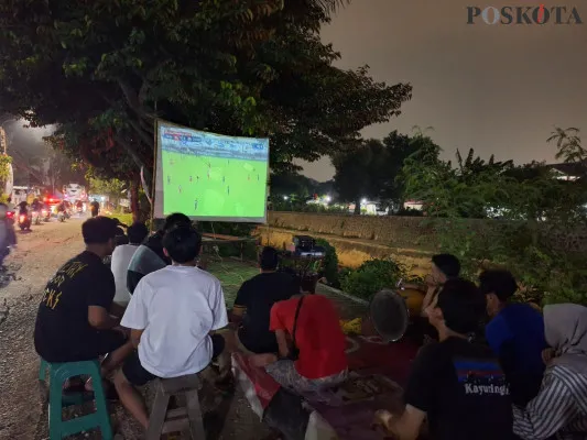 Warga antusias nonton bareng laga Timnas Indonesia lawan Jepang di pinggir Tanggul Kali Jati, Kayurungin, Bekasi Selatan. Jumat, 15 November 2024. (Poskota/Ihsan)