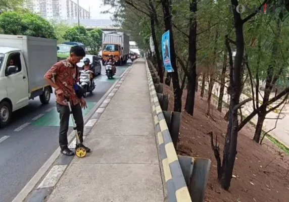 Petugas survei melakukan rekayasa dan mengukur pelebaran jalan di area simpang Pekayon, Bekasi Selatan, Kota Bekasi. (Poskota/Ihsan)