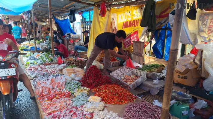 Iwan saat melayani pelangggan di lapak sayur mayur Pasar Baru, Bekasi Timur, Senin, 9 Desember 2024. (Poskota/Ihsan Fahmi)