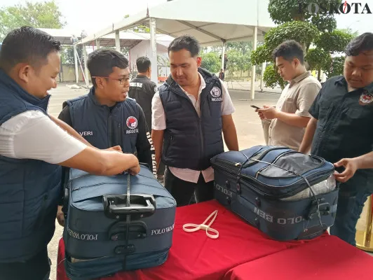 Personil Satreskoba Polres Serang mengamankan 2 koper berisi puluhan kilogram ganja. (Poskota/Rahmat)