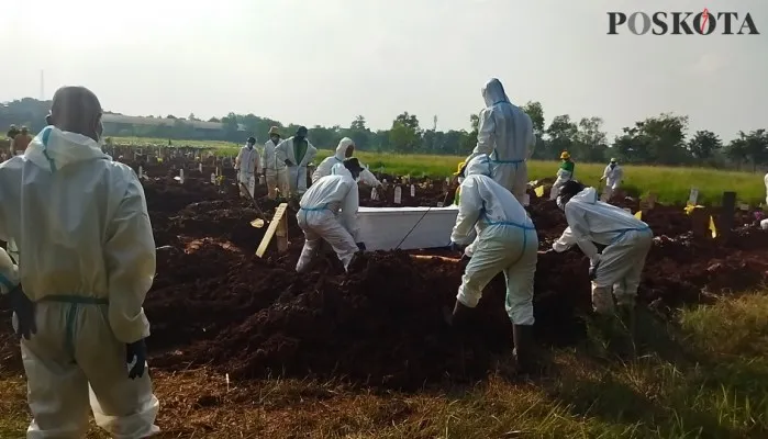 Petugas TPU Padurenan sedang memakamkan jenazah dengan protokol Covid-19. (cr02)