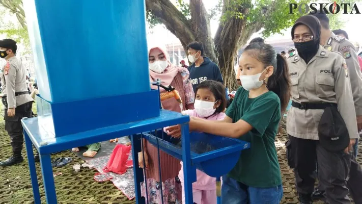 Petugas gabungan mengimbau pengunjung TMII agar menerapkan protokol kesehatan guna mencegah penularan virus Covid-19 yang hingga kini masih mewabah, Minggu (2/1/2021). (foto: poskota/ardhi) 