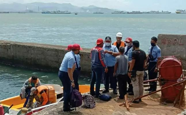 Petugas usai menyelamatkan kenek mobil travel yang tercebur dari atas KMP Kumala. (Ist)