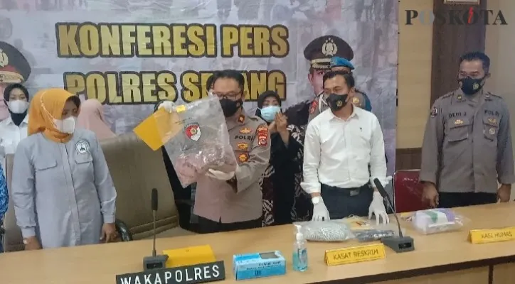 Wakapolres Serang, Kompol Feby Harianto, didampingi Kasatreskrim, AKP Dedi Mirza menunjukkan barang bukti kerudung yang digunakan untuk membalut bayi. (foto: poskota/haryono)