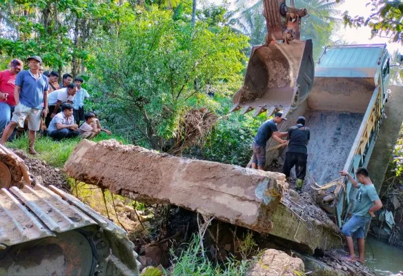 Belasan warga Tanjungan Pandeglang saat berusaha mengevakuasi mobil truk di jembatan ambruk. (Ist).