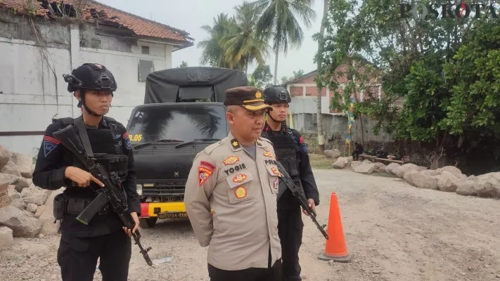 Sejumlah anggota Brimob saat berjaga di pintu masuk wisata Karangsari Carita Pandeglang. (Samsul Fatoni)