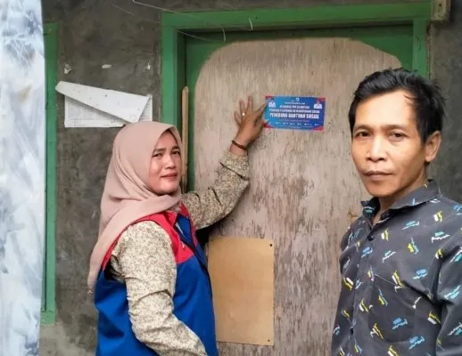 Petugas TKSK di Lebak saat pasang stiker di rumah warga miskin penerima Bansos. ist