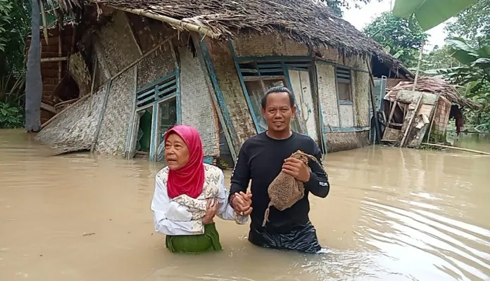 Ilman, Kades Idaman Pandeglang saat evakuasi salah satu korban banjir. (Foto: Ist).